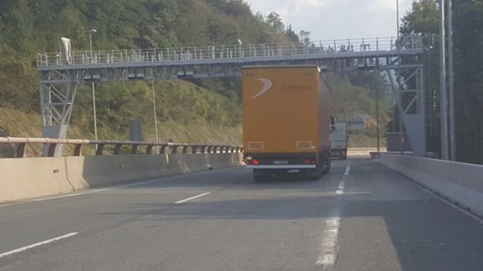 Un camión pasa bajo un pórtico para el cobro de peajes en la N1 en Guipúzcoa, en Etxegárate.