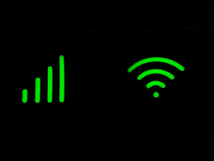 Símbolos de red wifi y de potencia de la red en verde sobre negro.