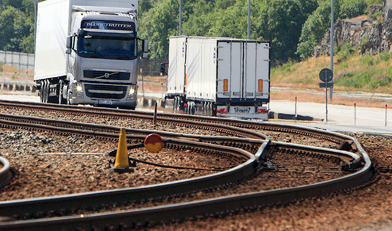 Un camión circula a la vez que un ferrocarril de mercancías.