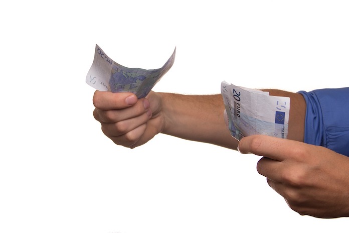 Un hombre saca billetes de euros de su cartera.