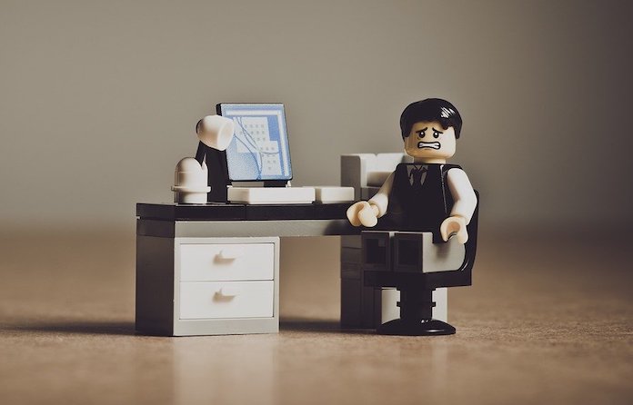 Lego: oficinista contrariado sentado en una mesa.